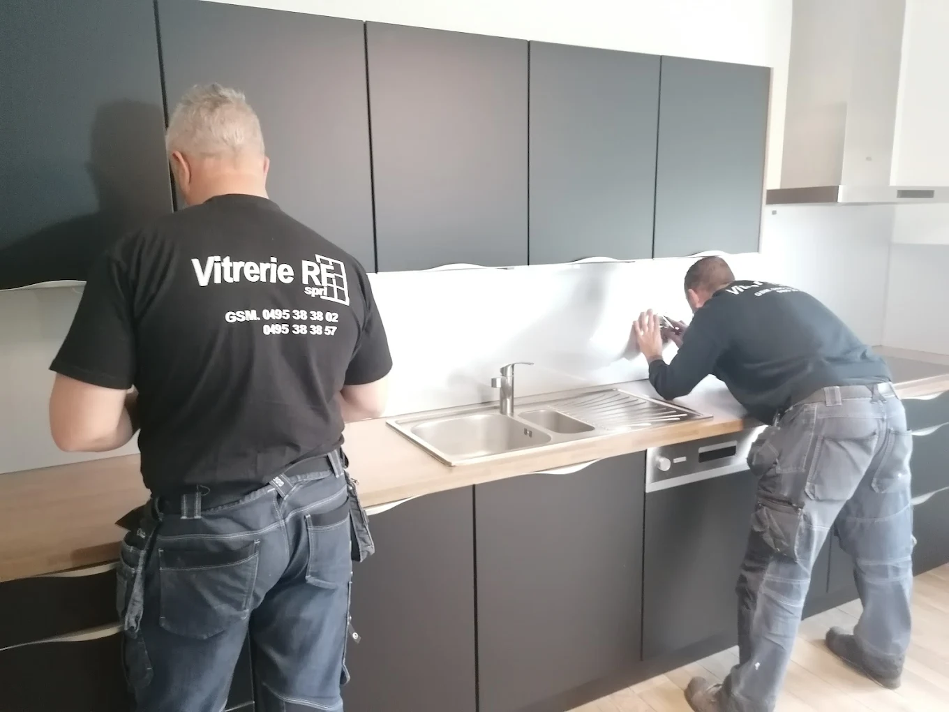 Patrons locaux de l'entreprise Vitrerie RF travaillant sur une crédence de cuisine