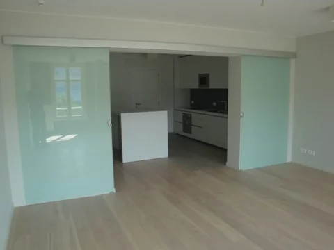 Porte coulissante en verre dépoli installée dans une maison à Nivelles