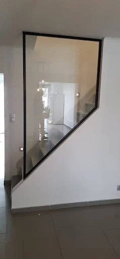 Paroi vitrée style atelier design sous escalier à Charleroi – Vitrerie RF
